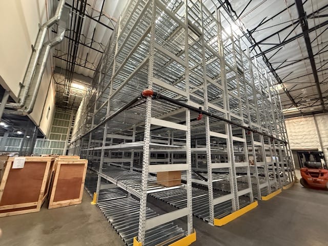 Multi-tier tube rack under installation with wire decking across each level in a Valencia, CA archive facility